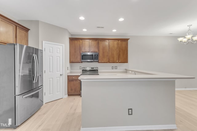 3634 Olympia Dr, Raleigh, NC 27603 - kitchen featuring stainless steel appliances, light wood-style floors, brown cabinets, a chandelier, and recessed lighting