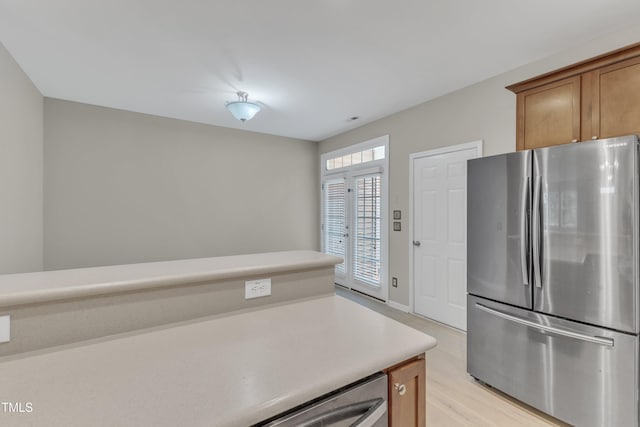3634 Olympia Dr, Raleigh, NC 27603 - kitchen featuring freestanding refrigerator, light wood finished floors, light countertops, and brown cabinetry