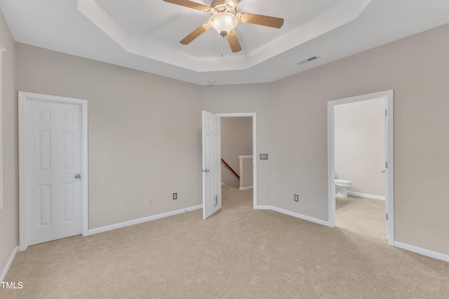 3634 Olympia Dr, Raleigh, NC 27603 - unfurnished bedroom with light colored carpet, a raised ceiling, and ensuite bath