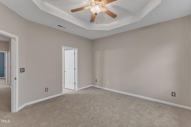 3634 Olympia Dr, Raleigh, NC 27603 - unfurnished bedroom featuring light carpet, a tray ceiling, and ceiling fan