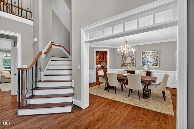 3748 Knollcreek Dr, Apex, NC 27539 - dining area featuring wood finished floors, stairway, ornamental molding, a towering ceiling, and a chandelier