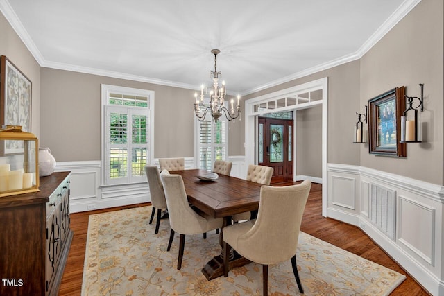 3748 Knollcreek Dr, Apex, NC 27539 - dining room with a chandelier, wood finished floors, crown molding, and a wainscoted wall