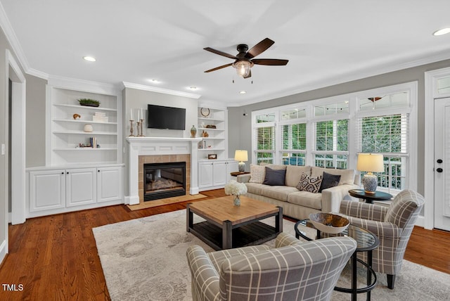 3748 Knollcreek Dr, Apex, NC 27539 - living area featuring ceiling fan, crown molding, healthy amount of natural light, a fireplace, and wood finished floors