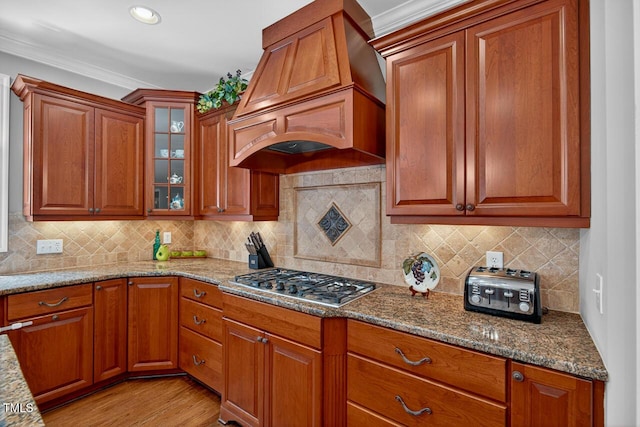 3748 Knollcreek Dr, Apex, NC 27539 - kitchen with premium range hood, stainless steel gas stovetop, brown cabinets, ornamental molding, and recessed lighting