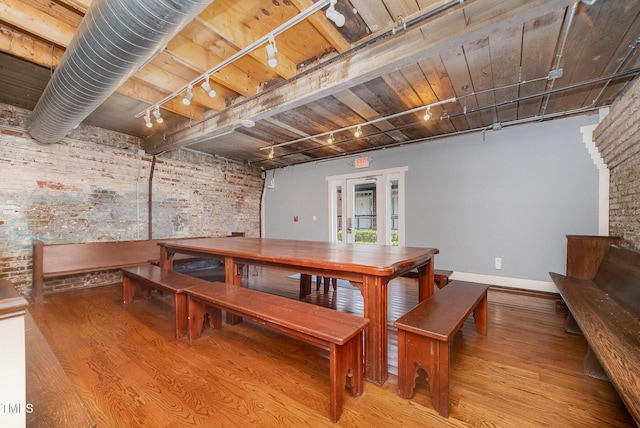 1535 Caraleigh Mills Ct Unit 142, Raleigh, NC 27603 - dining room featuring rail lighting, brick wall, and wood finished floors
