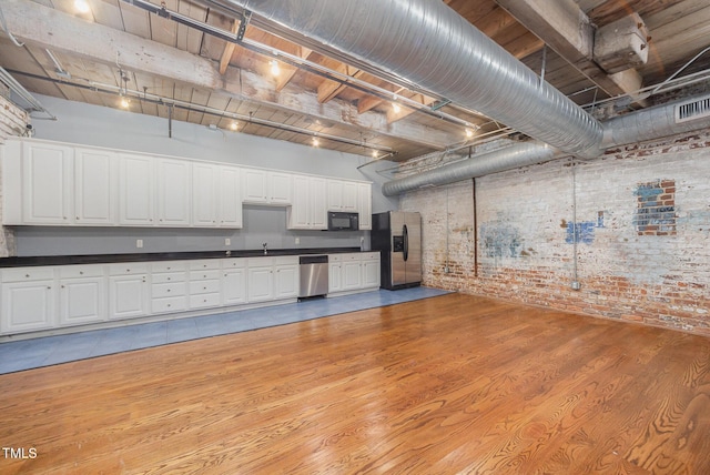 1535 Caraleigh Mills Ct Unit 142, Raleigh, NC 27603 - basement with brick wall, stainless steel refrigerator with ice dispenser, and light wood-style floors