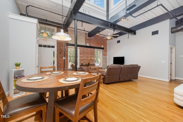 1535 Caraleigh Mills Ct Unit 142, Raleigh, NC 27603 - dining room with a towering ceiling, brick wall, light wood-style floors, a ceiling fan, and beam ceiling