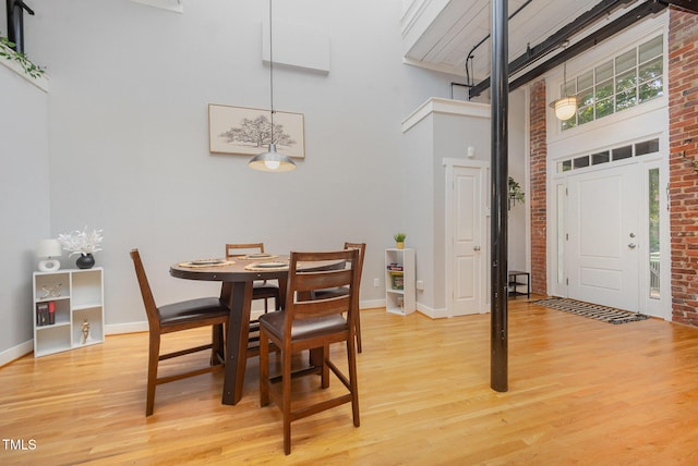1535 Caraleigh Mills Ct Unit 142, Raleigh, NC 27603 - dining area with a high ceiling, light wood-style floors, and brick wall