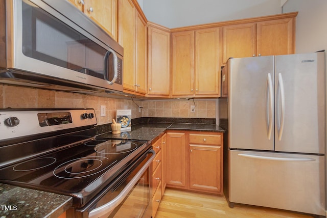 1535 Caraleigh Mills Ct Unit 142, Raleigh, NC 27603 - kitchen with stainless steel appliances, light wood-style floors, dark stone counters, and tasteful backsplash