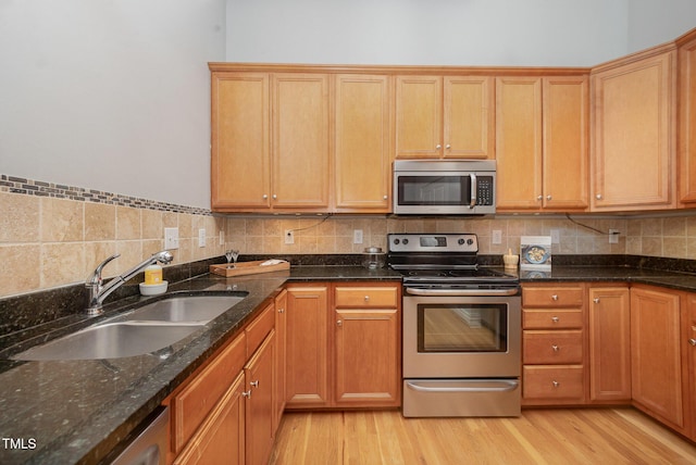1535 Caraleigh Mills Ct Unit 142, Raleigh, NC 27603 - kitchen with stainless steel appliances, light wood-style floors, dark stone counters, and tasteful backsplash
