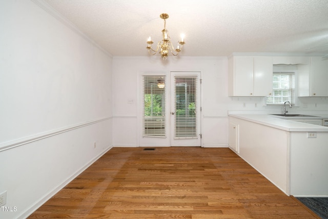 413 S Fayetteville St, Clayton, NC 27520 - unfurnished dining area with crown molding, a chandelier, light wood-style flooring, and a textured ceiling