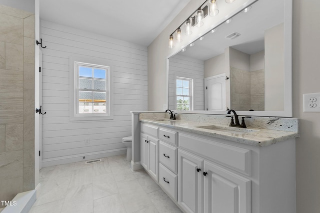 2379 Heartland Rd, Battleboro, NC 27809 - full bathroom featuring double vanity, plenty of natural light, marble finish floors, and wood walls
