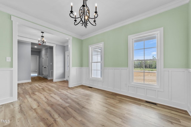2379 Heartland Rd, Battleboro, NC 27809 - unfurnished dining area with a chandelier, a wainscoted wall, crown molding, and light wood-type flooring