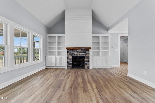 2379 Heartland Rd, Battleboro, NC 27809 - unfurnished living room featuring lofted ceiling, wood finished floors, and a stone fireplace