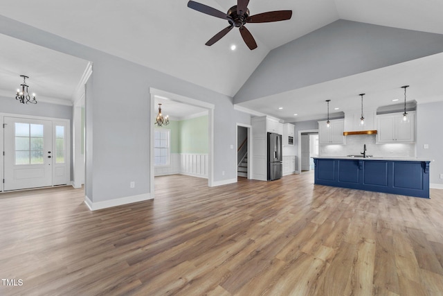 2379 Heartland Rd, Battleboro, NC 27809 - unfurnished living room with a chandelier, recessed lighting, light wood-type flooring, vaulted ceiling, and a ceiling fan