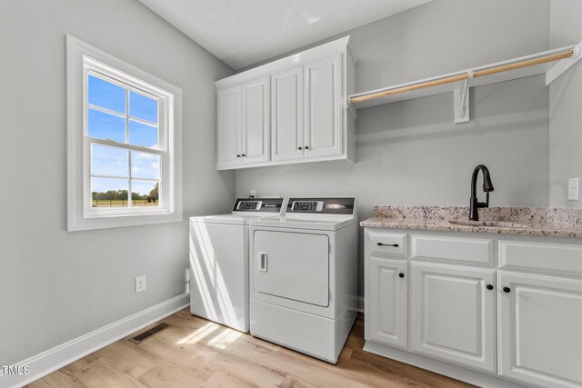 2379 Heartland Rd, Battleboro, NC 27809 - washroom featuring cabinet space, independent washer and dryer, and light wood finished floors