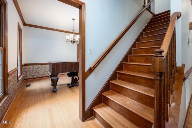 5020 Celbridge Pl, Raleigh, NC 27613 - stairs with crown molding, wood-type flooring, and a chandelier