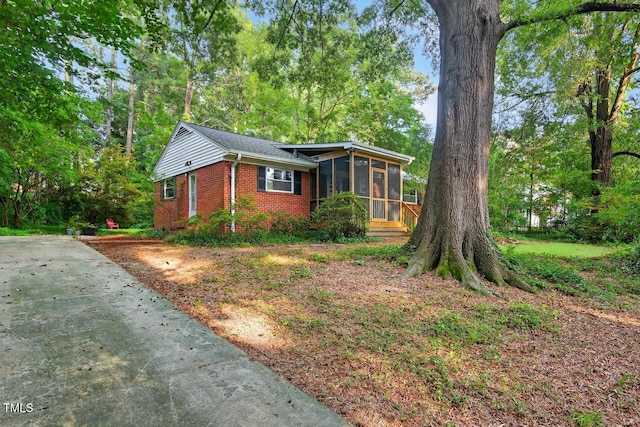 3215 Oxford Dr, Durham, NC 27707 - view of front of property featuring a sunroom, brick siding, and concrete driveway