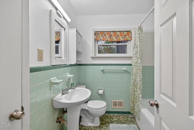 3215 Oxford Dr, Durham, NC 27707 - bathroom with shower / bath combination with curtain, wainscoting, tile walls, and tile patterned floors