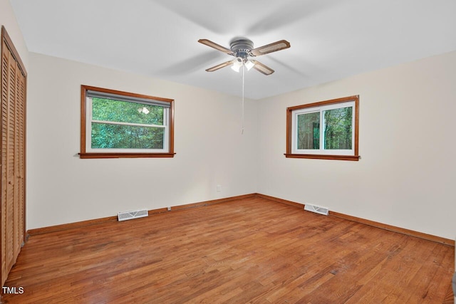 3215 Oxford Dr, Durham, NC 27707 - unfurnished bedroom with multiple windows, a closet, light wood-style flooring, and ceiling fan
