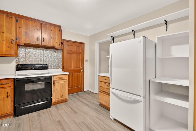 3215 Oxford Dr, Durham, NC 27707 - kitchen featuring freestanding refrigerator, range with electric stovetop, tasteful backsplash, and light countertops