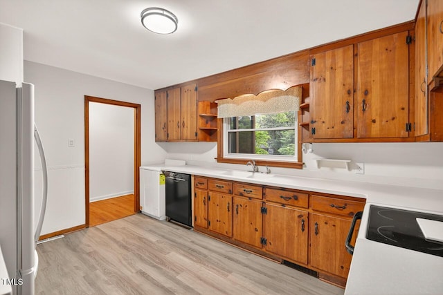 3215 Oxford Dr, Durham, NC 27707 - kitchen with black dishwasher, open shelves, freestanding refrigerator, light wood-type flooring, and light countertops