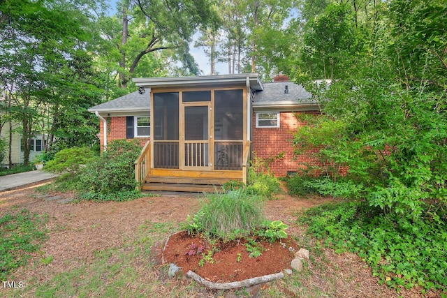 3215 Oxford Dr, Durham, NC 27707 - rear view of property featuring brick siding, a sunroom, and roof with shingles