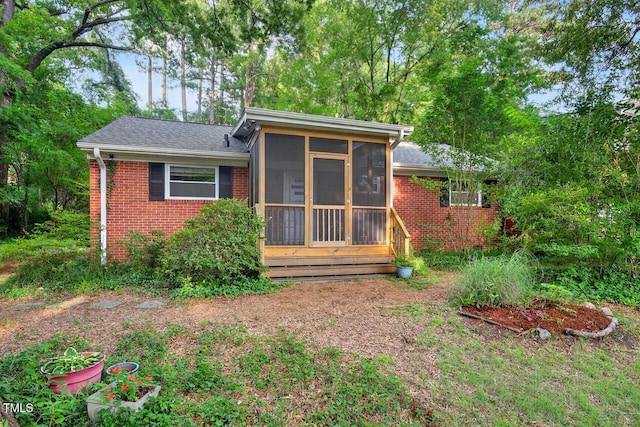 3215 Oxford Dr, Durham, NC 27707 - rear view of house featuring brick siding, a sunroom, and roof with shingles
