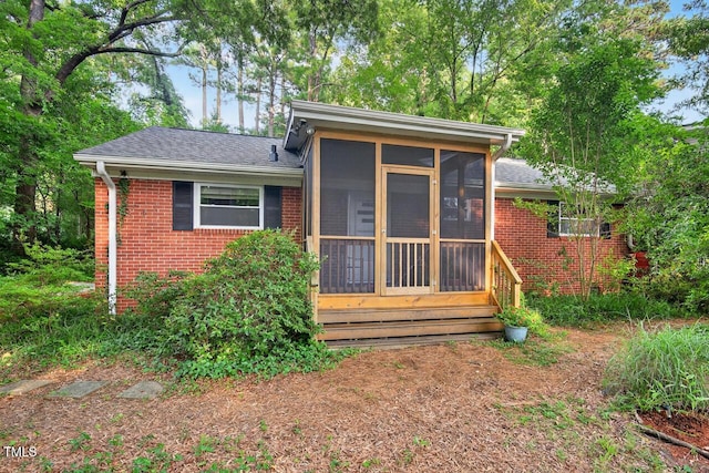 3215 Oxford Dr, Durham, NC 27707 - back of property with brick siding, a sunroom, and roof with shingles