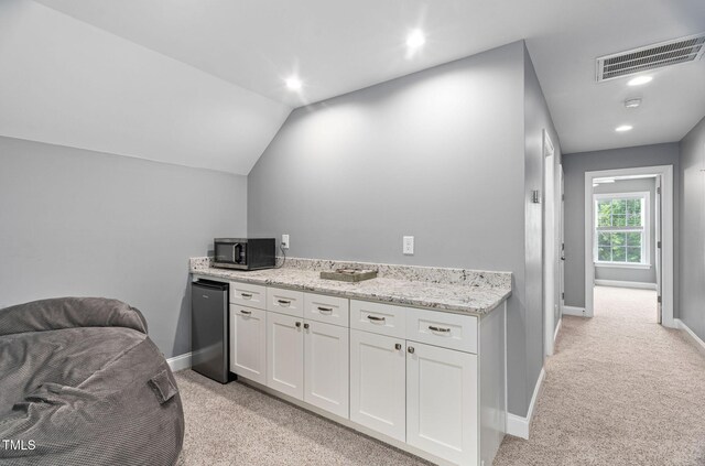 2712 Lake Waccamaw Trl, Apex, NC 27502 - kitchen with stainless steel appliances, light colored carpet, white cabinetry, light stone countertops, and recessed lighting