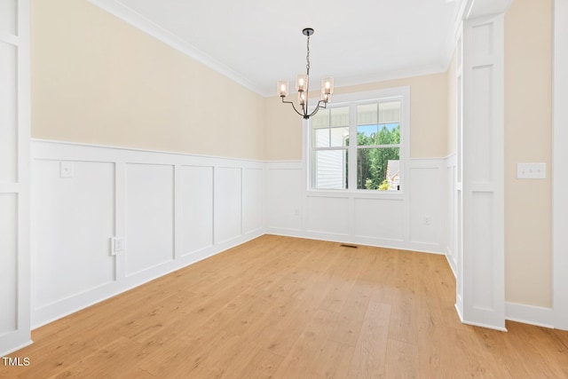 140 Purslane Dr, Franklinton, NC 27525 - spare room with a chandelier, crown molding, a decorative wall, light wood-style flooring, and wainscoting