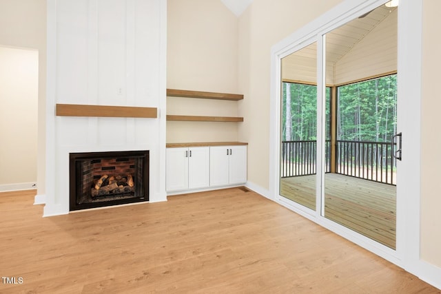 140 Purslane Dr, Franklinton, NC 27525 - unfurnished living room with light wood-style flooring, lofted ceiling, and a large fireplace