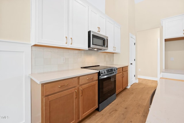 140 Purslane Dr, Franklinton, NC 27525 - kitchen featuring stainless steel appliances, light wood-type flooring, decorative backsplash, and white cabinetry