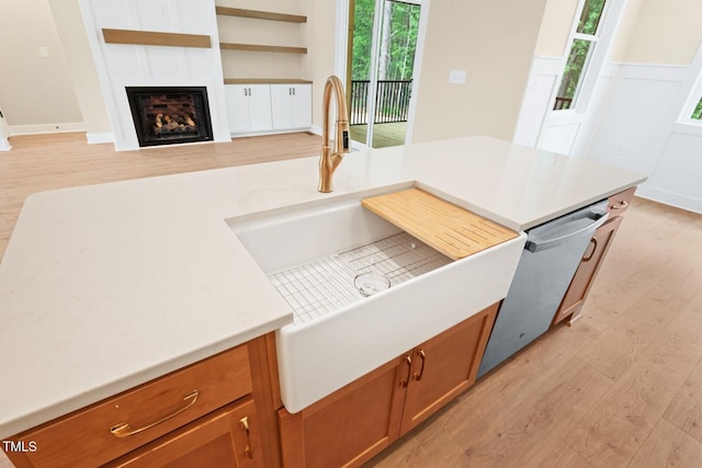 140 Purslane Dr, Franklinton, NC 27525 - kitchen featuring light wood-style floors, brown cabinets, and a large fireplace