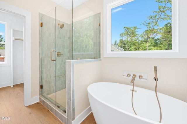 140 Purslane Dr, Franklinton, NC 27525 - full bath with a stall shower, a freestanding tub, and wood finished floors
