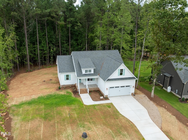 140 Purslane Dr, Franklinton, NC 27525 - view of front of house featuring driveway, a front yard, roof with shingles, covered porch, and a garage