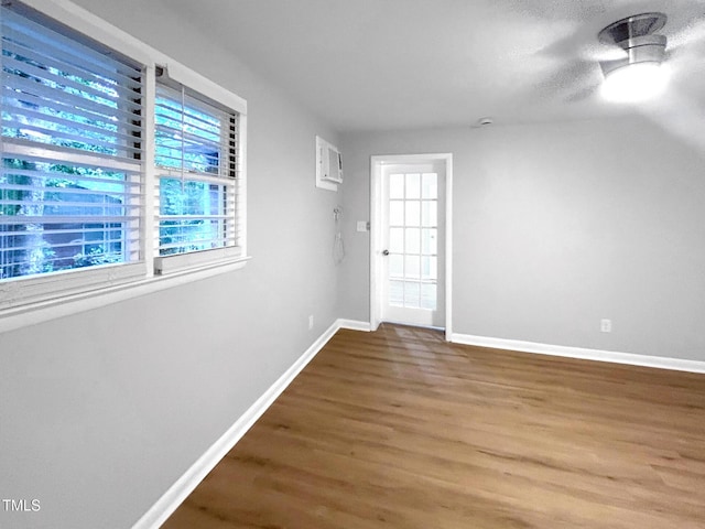 845 Newcombe Rd, Raleigh, NC 27610 - unfurnished room with wood finished floors, an AC wall unit, and a ceiling fan
