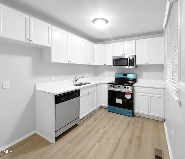 845 Newcombe Rd, Raleigh, NC 27610 - kitchen featuring stainless steel appliances, light wood-style flooring, white cabinets, and light countertops