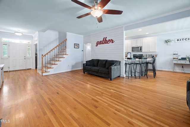 1824 Ferrell Meadows Dr, Zebulon, NC 27597 - living room with stairs, crown molding, a ceiling fan, and light wood-style flooring