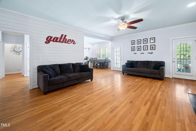 1824 Ferrell Meadows Dr, Zebulon, NC 27597 - living room with healthy amount of natural light, light wood-style flooring, a ceiling fan, ornamental molding, and wooden walls