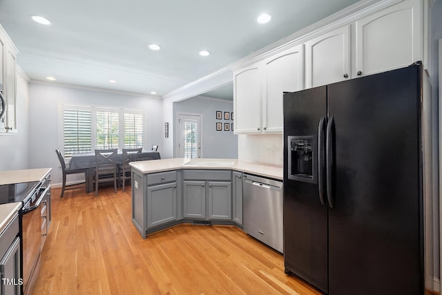 1824 Ferrell Meadows Dr, Zebulon, NC 27597 - kitchen with black fridge, stainless steel dishwasher, electric range oven, a peninsula, and white cabinetry