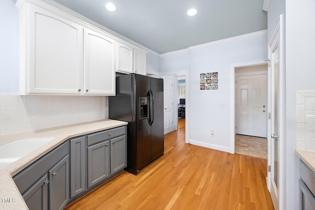 1824 Ferrell Meadows Dr, Zebulon, NC 27597 - kitchen with black fridge with ice dispenser, gray cabinets, white cabinets, backsplash, and light countertops