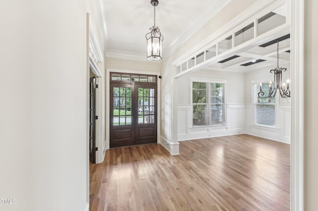 528 Bankhead Dr, Cary, NC 27519 - foyer entrance with a chandelier, light wood-style flooring, crown molding, french doors, and a decorative wall