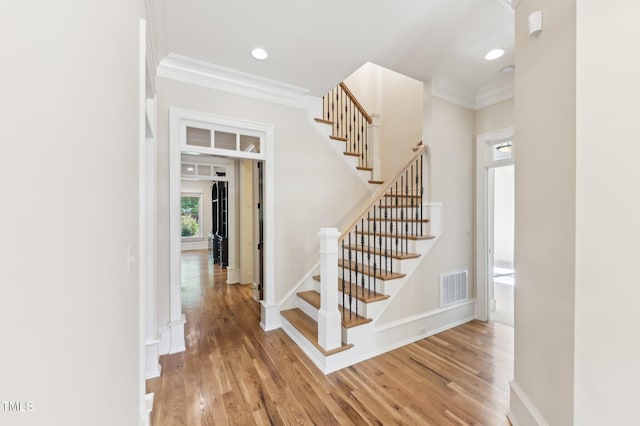 528 Bankhead Dr, Cary, NC 27519 - staircase with crown molding, wood finished floors, and recessed lighting