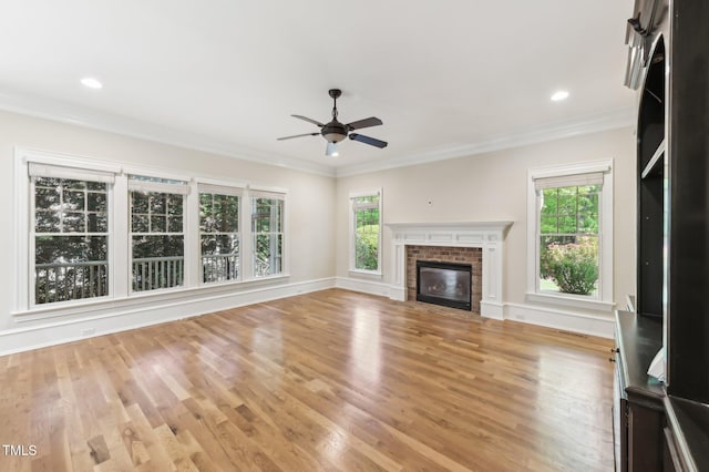 528 Bankhead Dr, Cary, NC 27519 - unfurnished living room featuring ceiling fan, a brick fireplace, light wood-style floors, ornamental molding, and recessed lighting