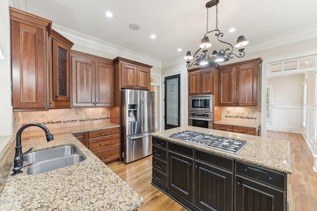 528 Bankhead Dr, Cary, NC 27519 - kitchen featuring appliances with stainless steel finishes, a center island, hanging light fixtures, light wood-style floors, and tasteful backsplash