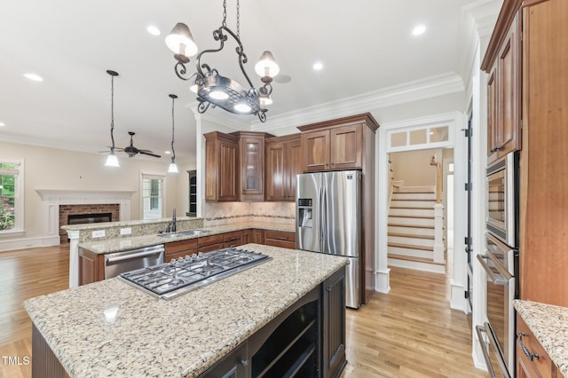 528 Bankhead Dr, Cary, NC 27519 - kitchen featuring appliances with stainless steel finishes, open floor plan, brown cabinets, ceiling fan, and healthy amount of natural light