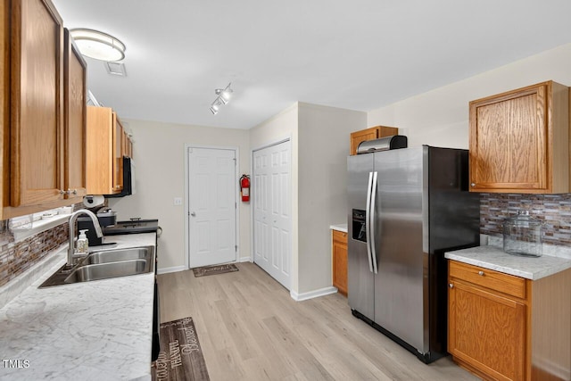 5 Ocean Ct, Durham, NC 27704 - kitchen featuring stainless steel fridge, light wood-style flooring, tasteful backsplash, light countertops, and brown cabinets