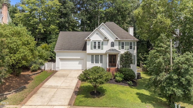 7908 Mayapple Pl, Raleigh, NC 27613 - view of front facade with concrete driveway, a chimney, an attached garage, a shingled roof, and view of wooded area