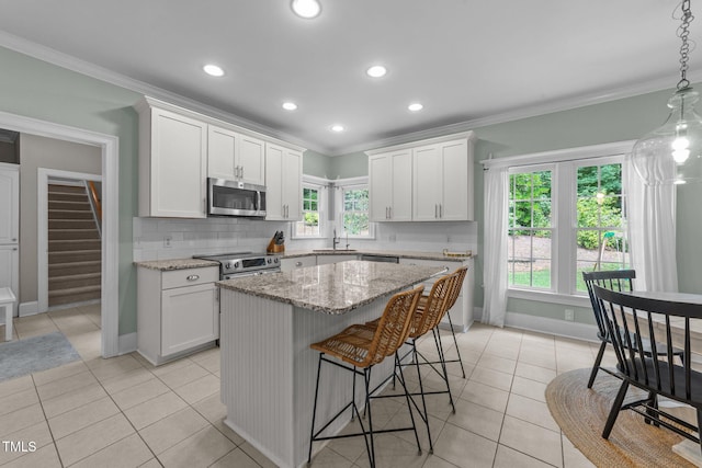 7908 Mayapple Pl, Raleigh, NC 27613 - kitchen featuring stainless steel appliances, light tile patterned floors, white cabinets, a breakfast bar area, and crown molding